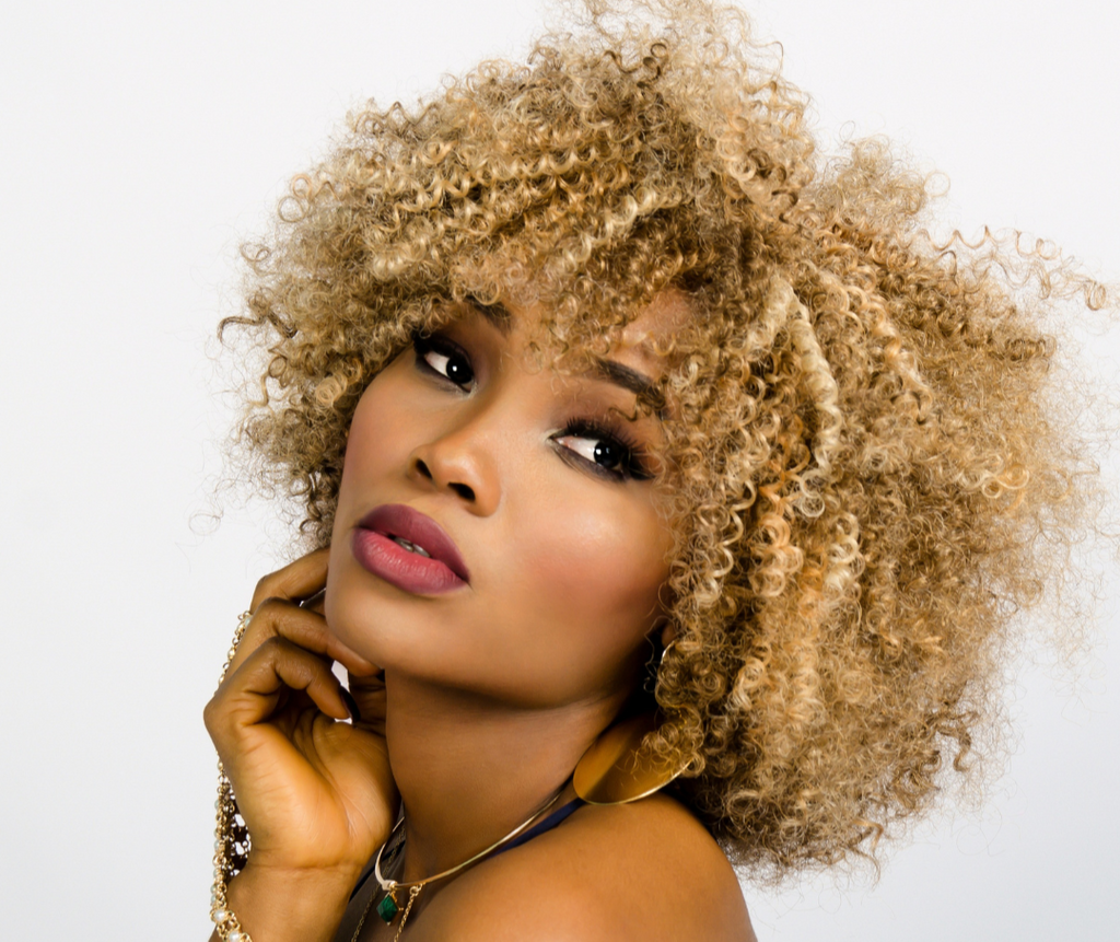 Woman with styled blonde hair against a white background