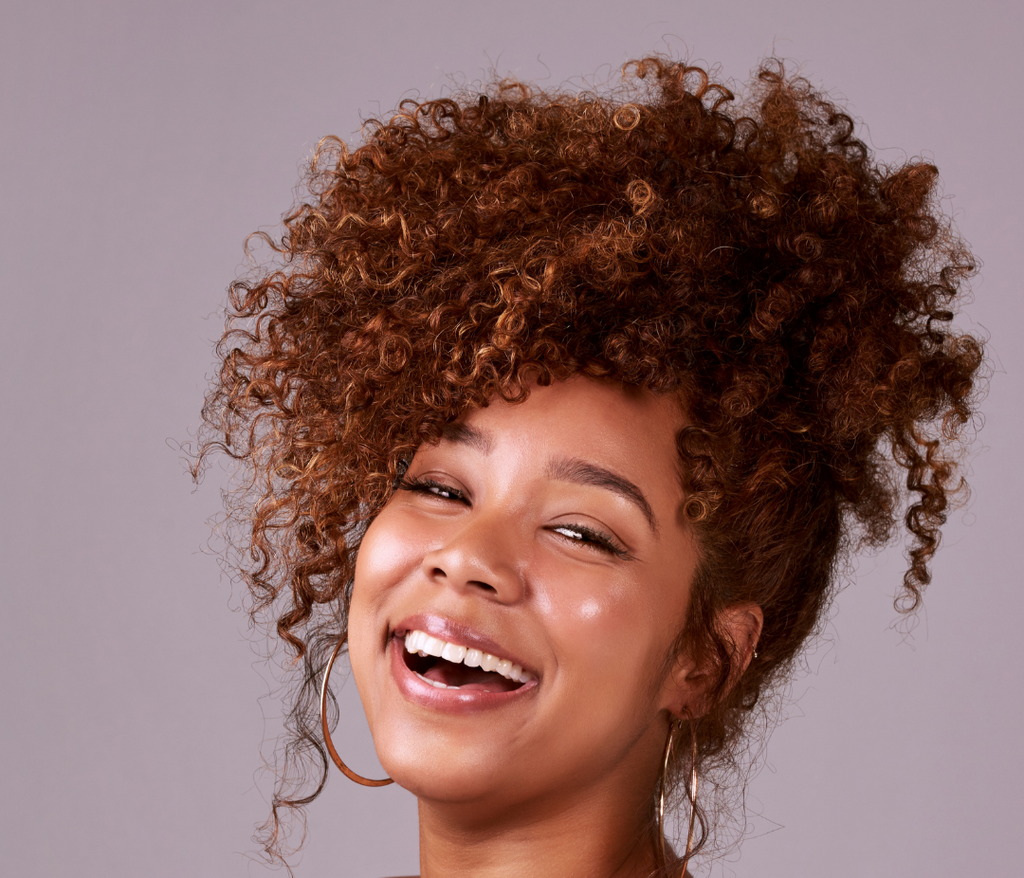 Woman with curly hair smiling against a light purple background, with text about curly hair being suitable for special occasions.